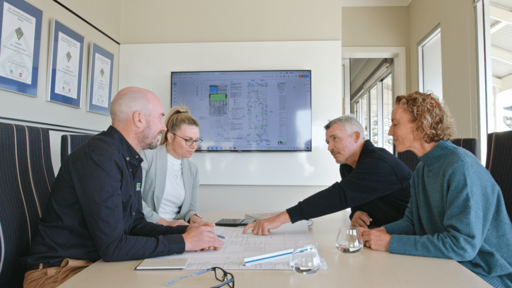 Brett and Elise talking to clients about their new home in their Henley Beach office