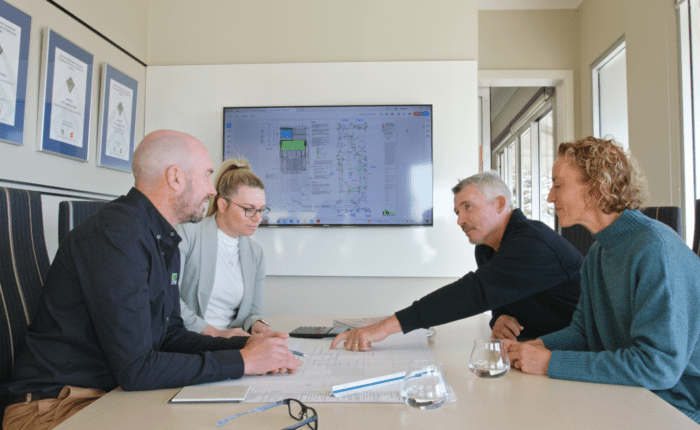 Brett and Elise talking to clients about their new home in their Henley Beach office