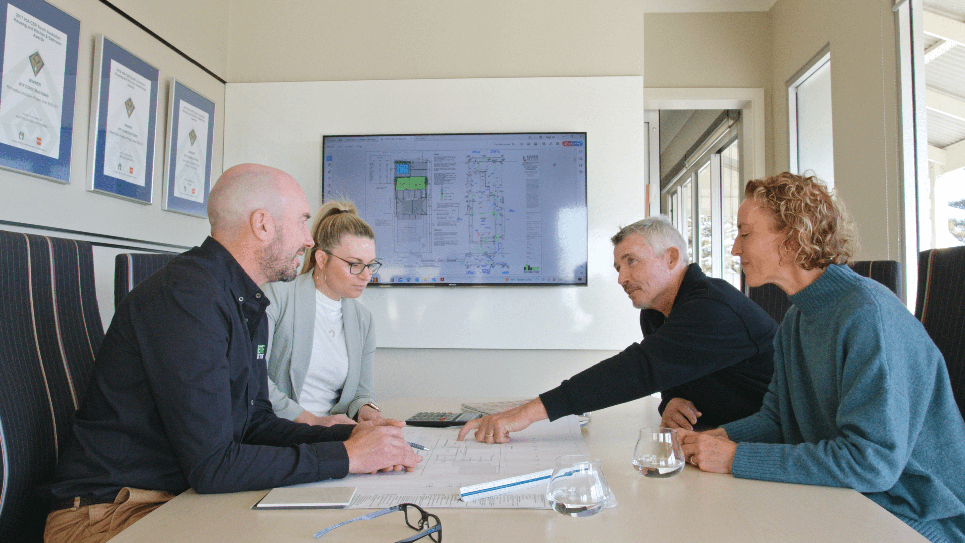 Brett and Elise talking to clients about their new home in their Henley Beach office