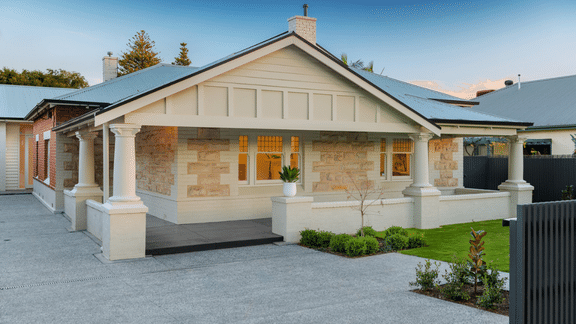 Renovated stone-fronted Adelaide bungalow with a traditional verandah, decorative timber detailing and landscaped garden.