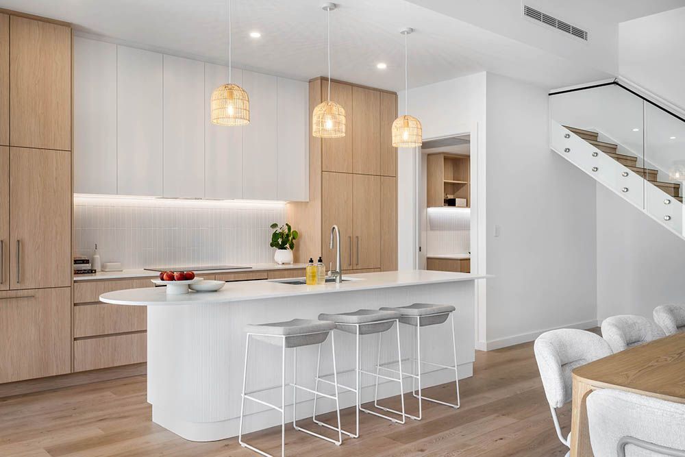 Contemporary kitchen in an extended character home with timber cabinetry, a curved island bench and pendant lighting.